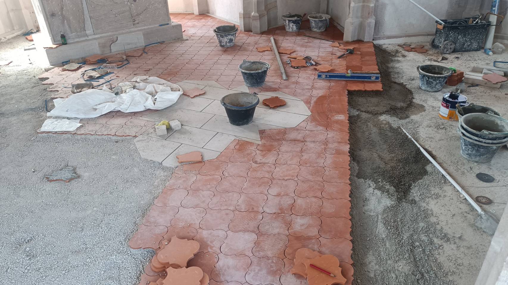 Laying geometric terracotta floor tiles in the chapel