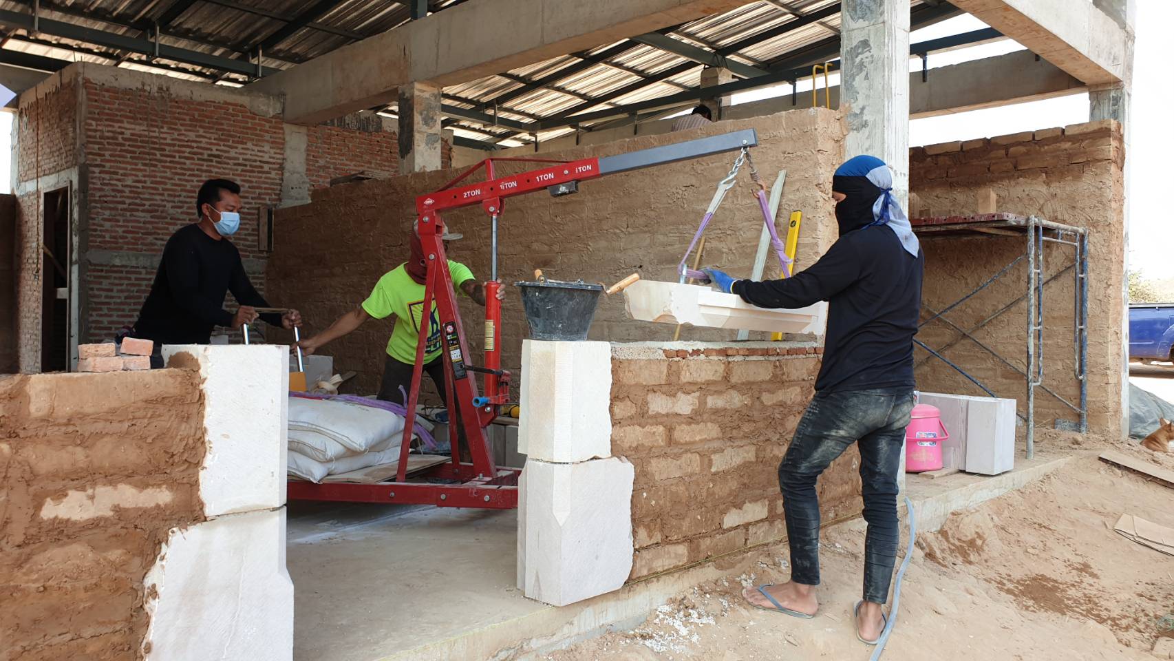 Concrete structure with earth block walls and carved stone frames